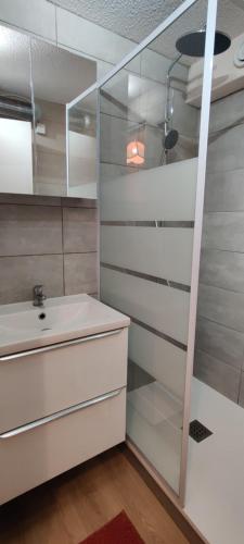 bagno con lavandino e parete in vetro di Appartement terrasse dans une résidence calme a Cap d'Agde