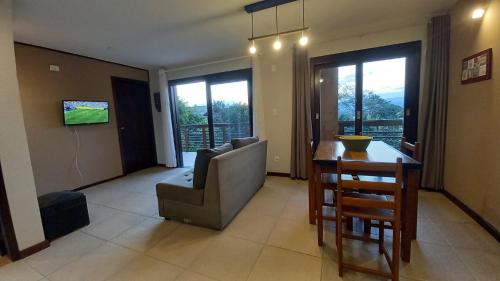 a living room with a couch and a chair and a table at Vila Tamú in Praia do Rosa
