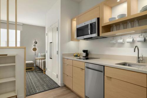 a kitchen with a sink and a microwave at TownePlace Suites by Marriott Williston in Williston