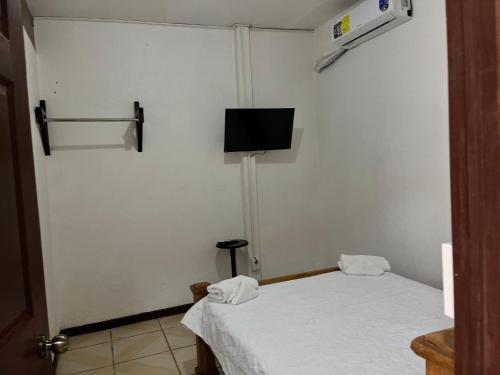 a room with a bed and a tv on the wall at Sleep&Go! Apartamento de 3 habitaciones in Siquirres