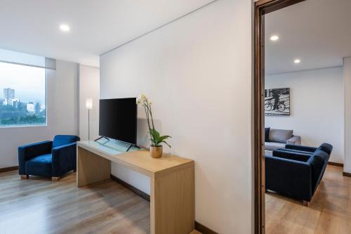 a living room with a desk and a mirror at Hotel Poblado Alejandria in Medellín