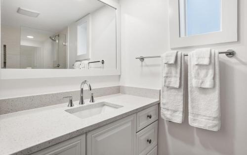 a white bathroom with a sink and a mirror at 401 Captain John Fripp Villa in Fripp Island