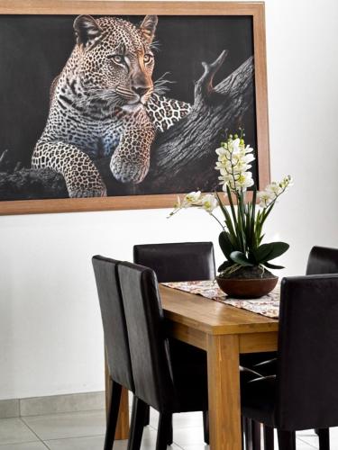 a dining room table with a painting of a leopard at El-Gibbor Residence 1 in Ermelo