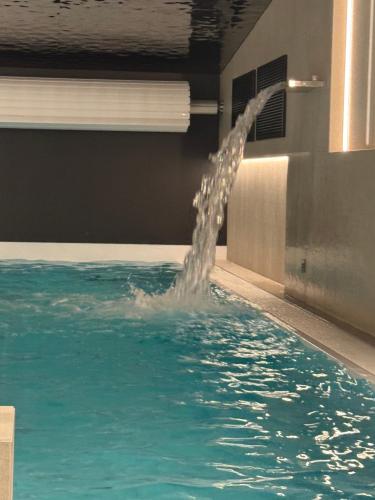 a water fountain in a swimming pool at Apartament INCOGNITO PREMIUM & SPA in Białka Tatrzanska