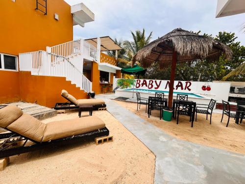 an outdoor patio with chairs and an umbrella at Babymar departamentos a 2 cuadras de la playa. in Chuburná