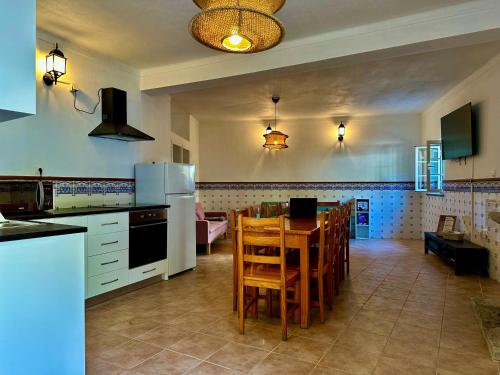 a kitchen with a table and chairs in a room at Égua Nature House in Piódão