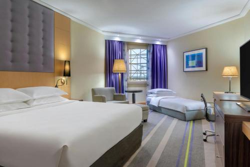 a hotel room with two beds and a television at Sheraton Brussels Airport Hotel in Zaventem