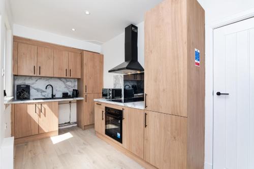 a kitchen with wooden cabinets and a stove at 2 Bedroom House-Free Parking in Methil