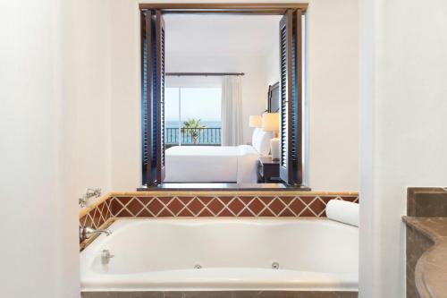 a bath tub in a bathroom with a mirror at Hacienda del Mar Los Cabos, an Autograph Collection All-Inclusive Resort in Cabo San Lucas