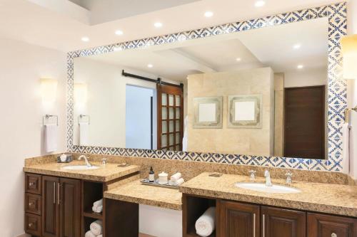 a bathroom with two sinks and a large mirror at Hacienda del Mar Los Cabos, an Autograph Collection All-Inclusive Resort in Cabo San Lucas