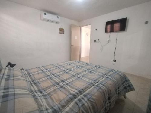 a bedroom with a bed and a tv on the wall at Casa 644 in Mérida
