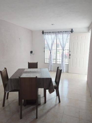 a dining room with a wooden table and chairs at Casa 644 in Mérida