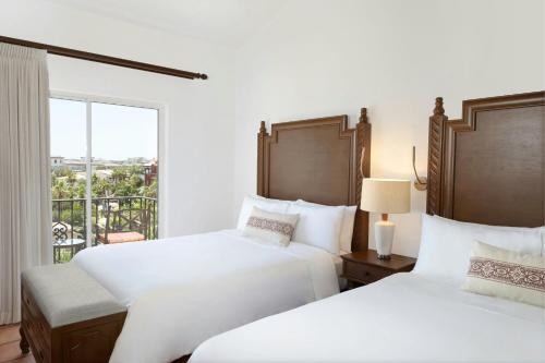 two beds in a hotel room with a balcony at Hacienda del Mar Los Cabos, an Autograph Collection All-Inclusive Resort in Cabo San Lucas