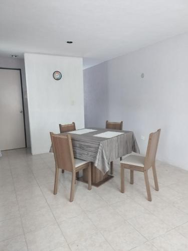 a dining room with a table and four chairs at Casa 644 in Mérida