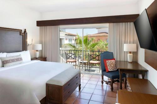 a bedroom with a bed and a desk and a balcony at Hacienda del Mar Los Cabos, an Autograph Collection All-Inclusive Resort in Cabo San Lucas