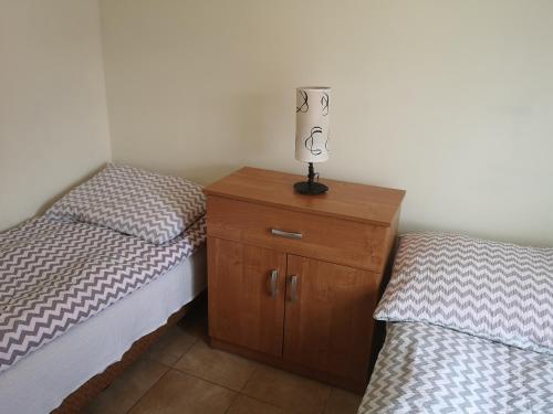 una lampada sopra una cassettiera tra due letti di Domki letniskowe Reda a Rusinowo