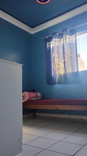 a room with a blue wall with a bed in it at Casa em Araucária in Araucária