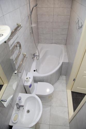 a bathroom with a tub and a toilet and a sink at Studio at Tsentralnyi Prospekt in Mykolaiv