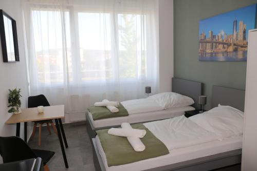 two beds in a small room with a window at Ok Apartments in Pforzheim