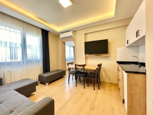 a living room with a couch and a table with chairs at Haven Apart Hotel INN in Trabzon