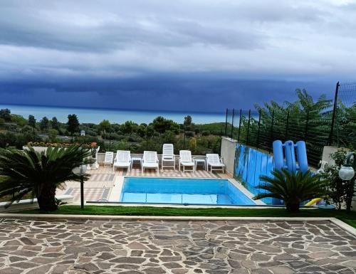a pool with chairs and a view of the ocean at Comfort &Relax B&B&Spa in Villa Rosa