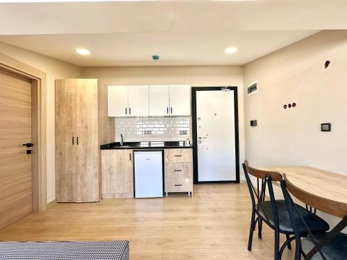 a kitchen with a wooden table and a dining room at Haven Apart Hotel INN in Trabzon