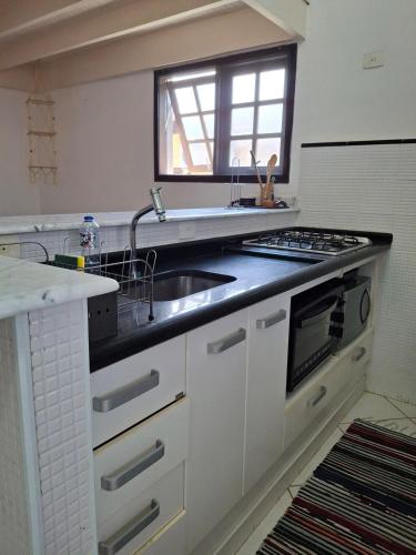 a kitchen with a sink and a stove at Flat na Praia de Maresias - 100 metros da praia in São Sebastião
