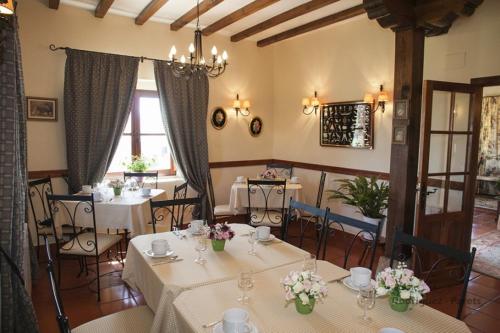 ein Restaurant mit Tischen und Stühlen mit Blumen darauf in der Unterkunft Costa Trasmiera in Langre