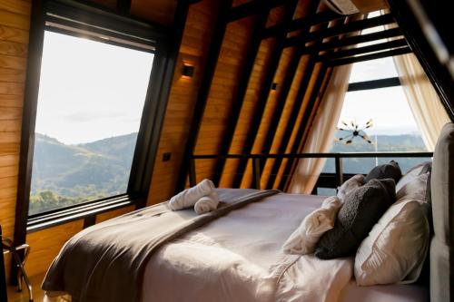 a bed in a room with large windows at Cabana Silfra in Gonçalves