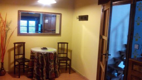 a room with a table and chairs and a mirror at Antigua Posada, Valle del Jerte in Tornavacas