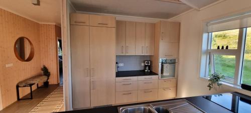 a kitchen with white cabinets and a window at Luxury Family Getaway in Selfoss