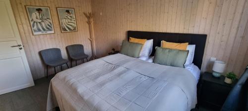 a bedroom with a large bed and two chairs at Luxury Family Getaway in Selfoss