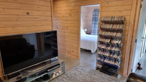 a living room with a flat screen tv and a bedroom at Goods Guest house in Waikino