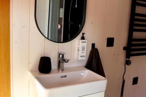 a bathroom with a sink and a mirror at Mirage - Dreamy Seaside Design Cabin in Engure