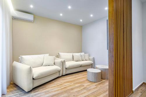 a living room with two white couches in a room at Azure Bliss in Nikiti