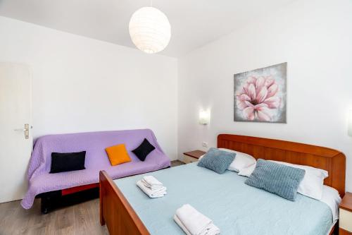 una camera con due letti e un divano viola di Apartment Baras a Nin