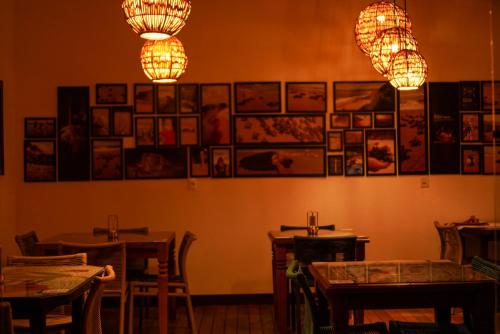 a restaurant with tables and chandeliers and pictures on the wall at Xamã Senses - Hotel Pousada in Pipa
