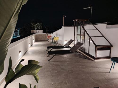 a rooftop patio at night with chairs and tables at La Terrazza Del Sole di Mondello in Palermo
