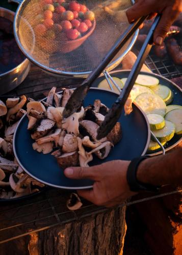 a person holding a plate of food on a grill at Samas Lasal - Hotel La Saladita in Temalhuacán