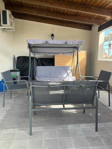 a bed with a canopy in a room with two chairs at Blue Terrace Guest House in Alghero