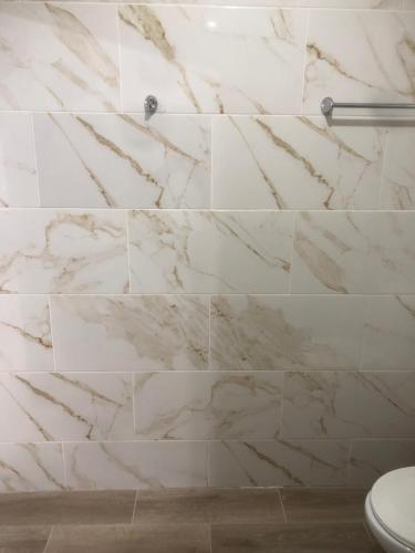 a bathroom with white marble walls and a toilet at Apartamento de lujo amueblado Guadeca B in Juan López