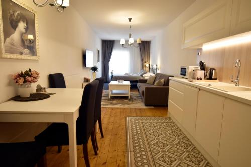 a kitchen and living room with a table and a couch at Apartmány MÚDRA SOVA in Banská Štiavnica