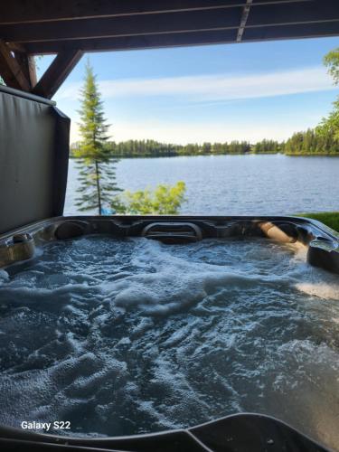 a jacuzzi tub with a view of a lake at La Belle Vie in Saint Ludger de Milot