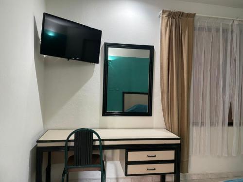 a desk with a mirror and a chair in a room at Hotel Tamazunchale in Tamazunchale