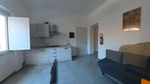 a living room with a couch and a kitchen at Sant Antioco Yellow Apartment with 2 Way Air Con in SantʼAntìoco