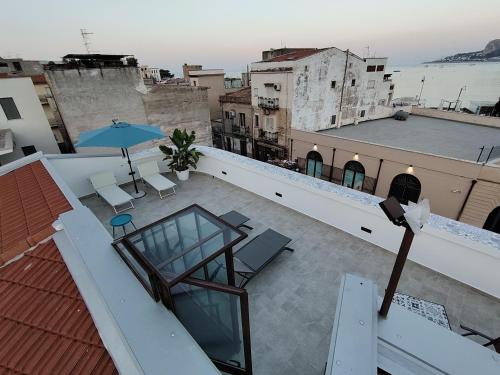a balcony with an umbrella and chairs on a roof at La Terrazza Del Sole di Mondello in Palermo