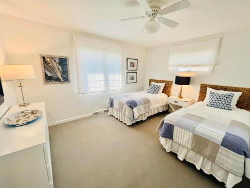 Un dormitorio con dos camas y un ventilador de techo. en Salisbury street 207, en Rehoboth Beach