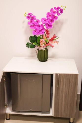 a vase of flowers sitting on top of a tv at Lofts Mediterraneo in Barranquilla