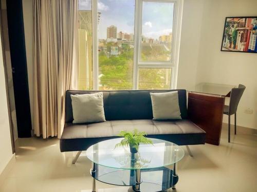 a living room with a couch and a glass table at Lofts Mediterraneo in Barranquilla