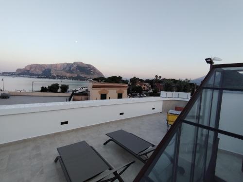 a balcony with chairs and a view of the water at La Terrazza Del Sole di Mondello in Palermo